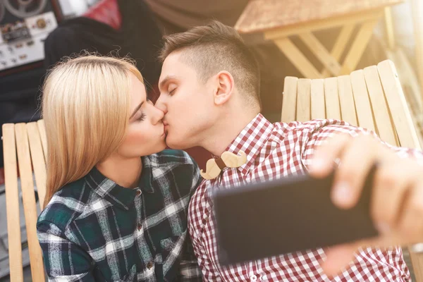 Fröhliche junge Liebende fotografieren ihren Kuss — Stockfoto
