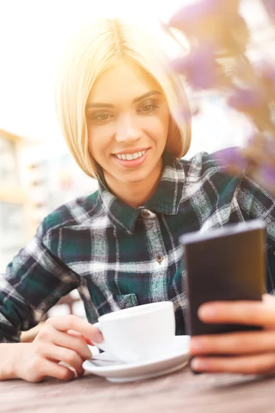 Jovem alegre está usando a tecnologia moderna — Fotografia de Stock