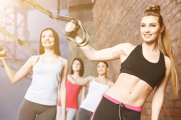 Mulheres jovens atraentes estão fazendo exercícios juntos — Fotografia de Stock