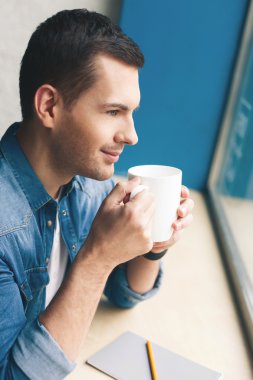 Çekici genç adam sıcak içecek keyfi