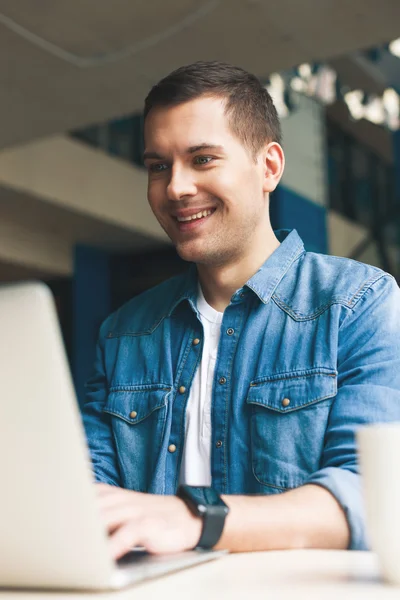 Trabalhador masculino alegre está digitando no notebook — Fotografia de Stock