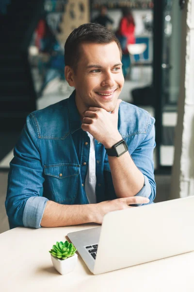 Çekici adam bir dizüstü bilgisayar üzerinde çalışıyor