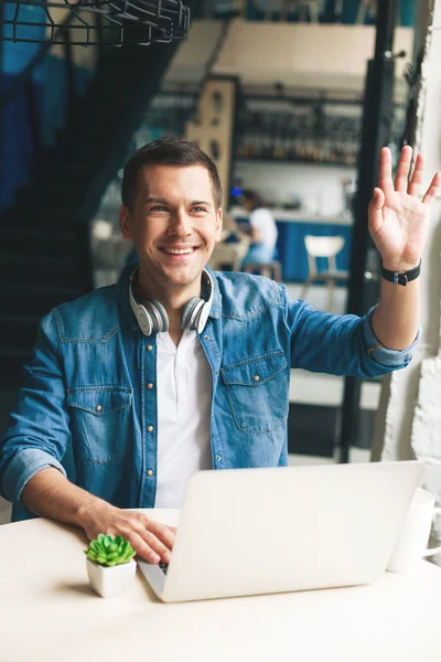 Bel ragazzo sta salutando qualcuno in mensa — Foto Stock