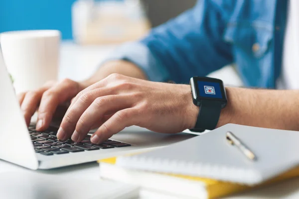 Jovem alegre está trabalhando no laptop — Fotografia de Stock