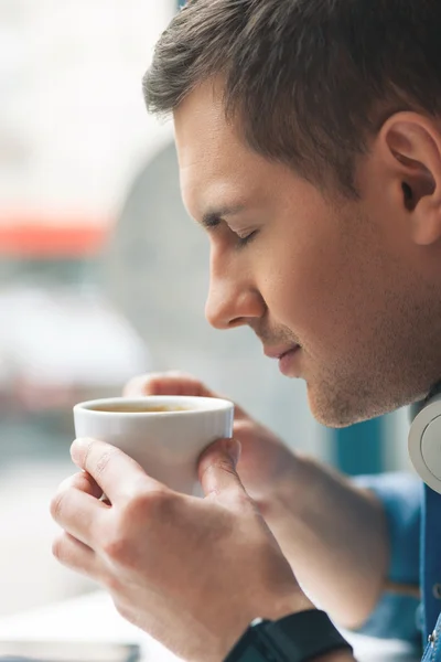Cheerful man is drinking hot beverage — Stock Photo, Image