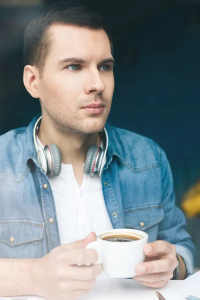 Attractive young guy is drinking hot beverage — Stock Photo, Image