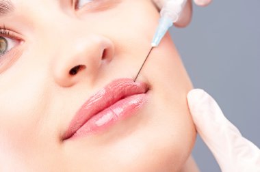 Neşeli genç kadın kollajen enjeksiyonu oluyor