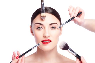 Genç bir modelin yakınında çeşitli makyaj fırçaları