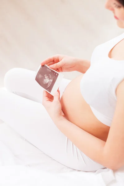 Pretty gravid kvinna håller ultraljud foto — Stockfoto