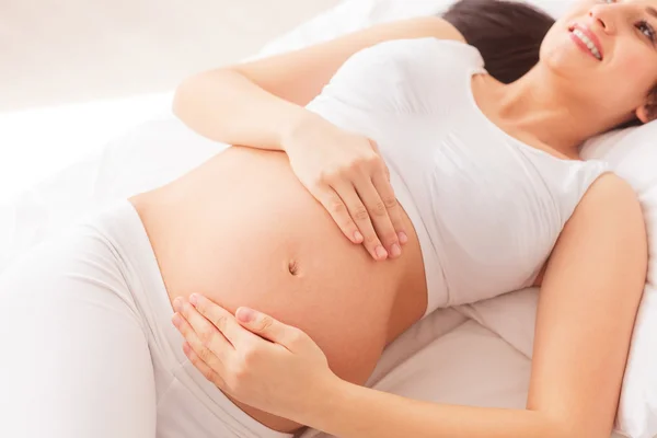Neşeli hamile kadın evde dinleniyor — Stok fotoğraf