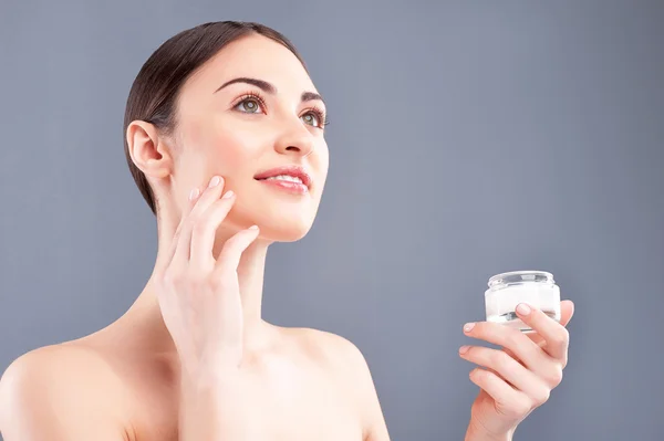 Beautiful young woman is treating her skin — Stock Photo, Image