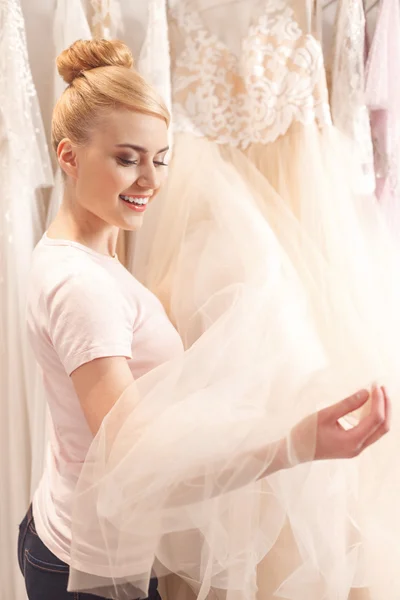 Attractive blond woman is selecting bridal gown — Stock Photo, Image