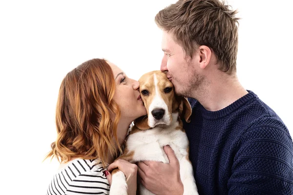 Casal alegre beija seu cão — Fotografia de Stock