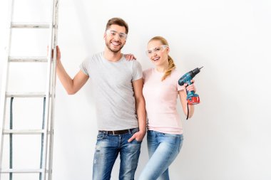 Adam ve kız merdiven yanında beyaz duvarının yakınında ayakta