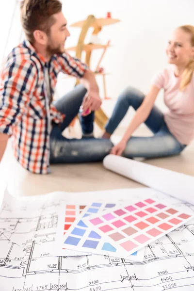 Pareja alegre discutiendo plan de casa de construcción — Foto de Stock