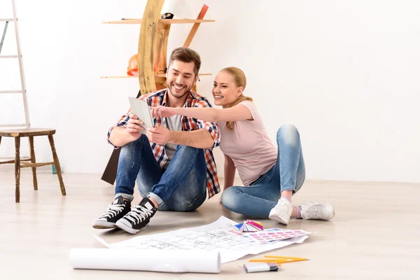 Lächelndes Paar diskutiert Wohnungsgrundriss — Stockfoto