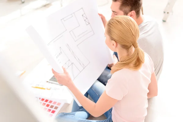 Junges Paar sucht Plan für sein Haus — Stockfoto