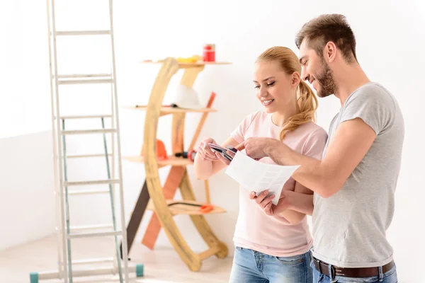 Young couple holding color palette — Stock Photo, Image