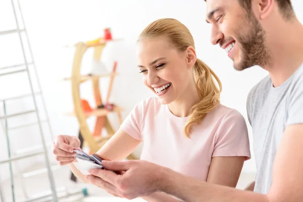 Young couple holding color palette — Stock fotografie