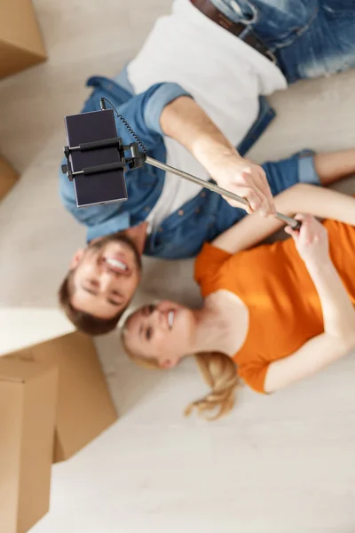 Young couple taking picture on floor — ストック写真