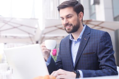 Yakışıklı genç adam dizüstü bilgisayarda yazıyor