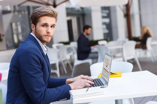 Vrolijke man werkt op computer in restaurant — Stockfoto