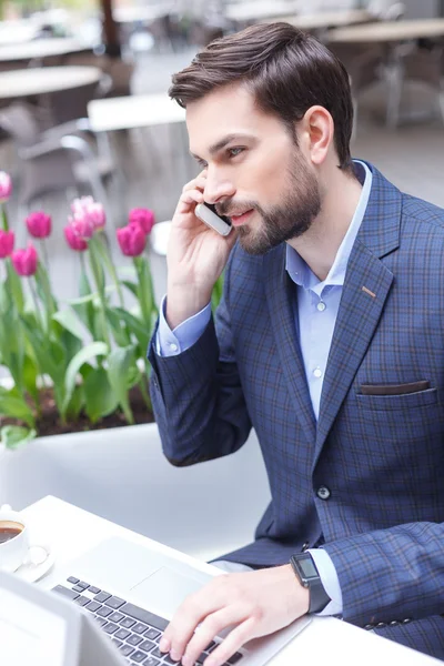 Atrakcyjny biznesmen komunikuje się na telefon — Zdjęcie stockowe