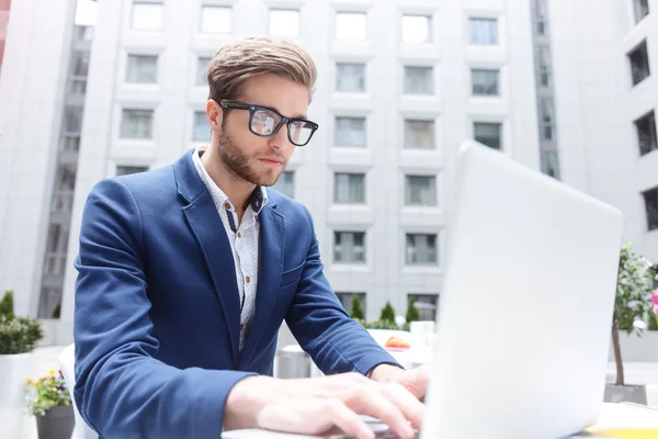 Allegro lavoro maschile sta utilizzando il computer portatile in caffè — Foto Stock