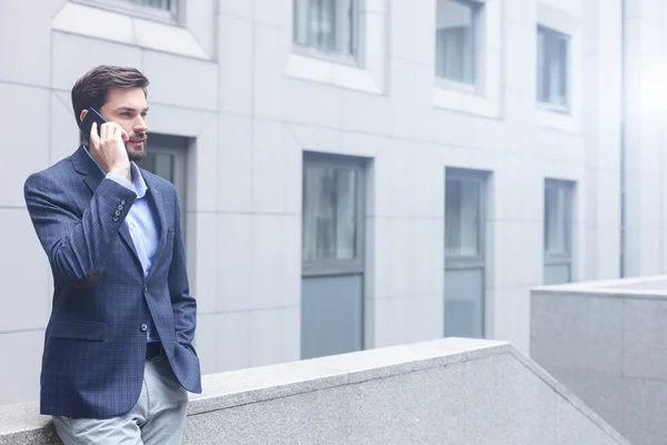 Hombre guapo está hablando por teléfono al aire libre — Foto de Stock