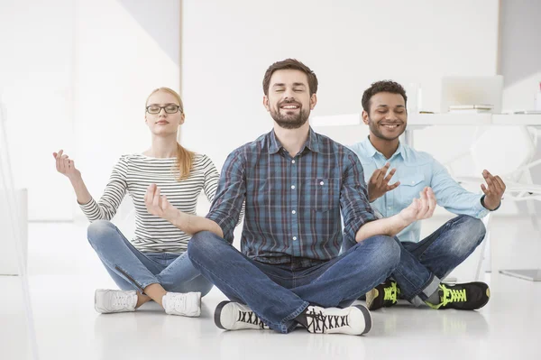 Företag som gör yoga på golvet i office — Stockfoto