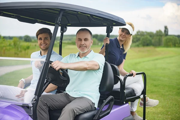 Привлекательная семья в гольф-каре — стоковое фото