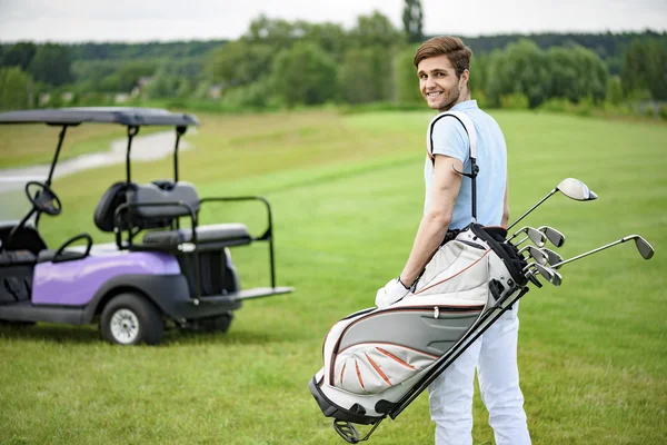 Golfista caminhando com sacos de golfe — Fotografia de Stock