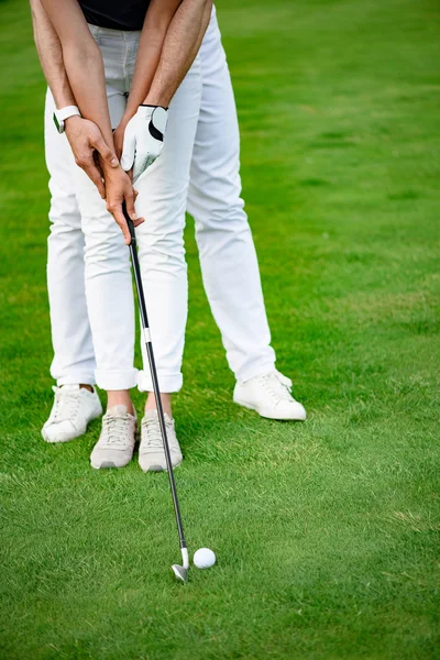 Парень учит свою девушку играть в гольф — стоковое фото
