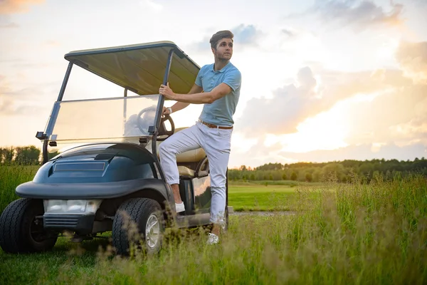 Yuong cara ficando no carrinho de golfe — Fotografia de Stock