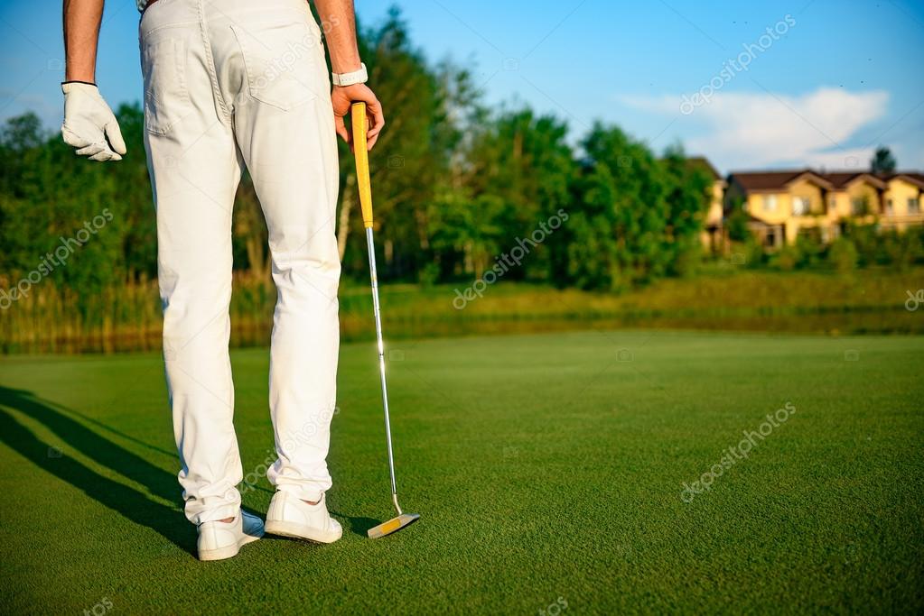 That was great drive. Close up of rear-view of man looking over golf course after shot, holding driver