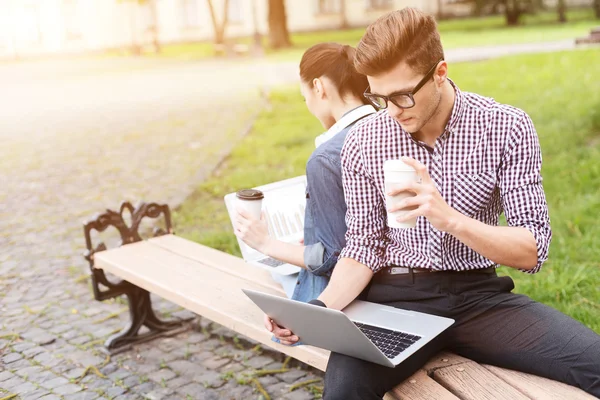Pretty guy and girl are studying outdoors — Stock Photo, Image