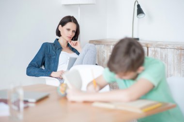 Young teenage boy studying at desk