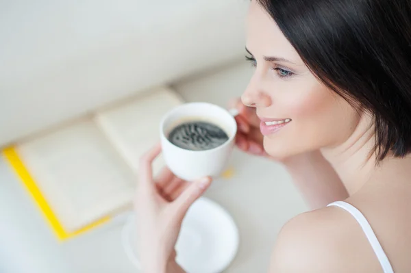Привлекательная женщина пьет кофе дома — стоковое фото