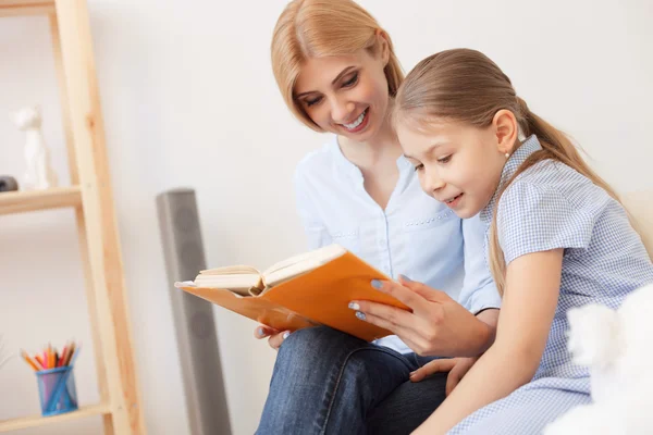 Mãe e filha lendo livro em casa — Fotografia de Stock