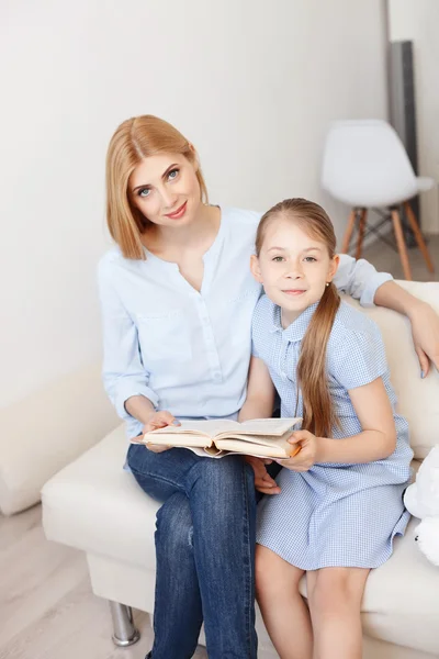 Mãe e filha lendo livro em casa — Fotografia de Stock