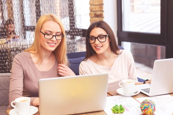Joyful två kvinnor som arbetar med dator tillsammans — Stockfoto