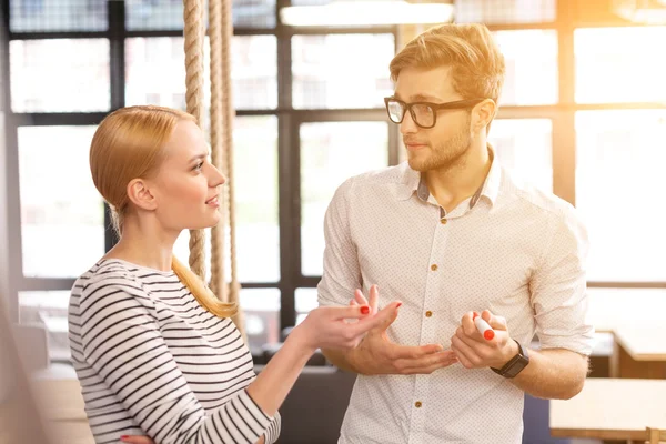 Vrolijk creatief team dat over werk praat — Stockfoto