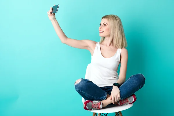 Pretty young woman photographing herself on telephone — Stock Photo, Image