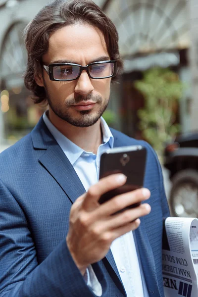 Confident businessman using telephone outdoors