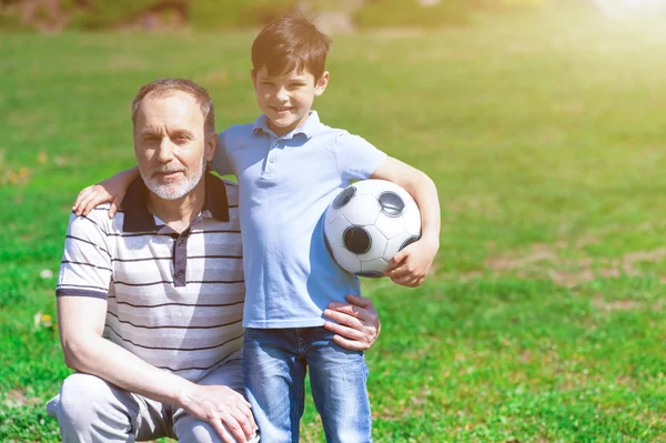 Velho alegre e seu neto jogando futebol — Fotografia de Stock