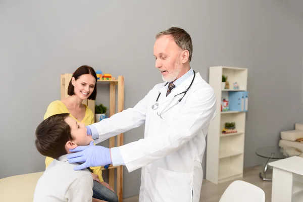 Kinderarzt untersucht Kind — Stockfoto