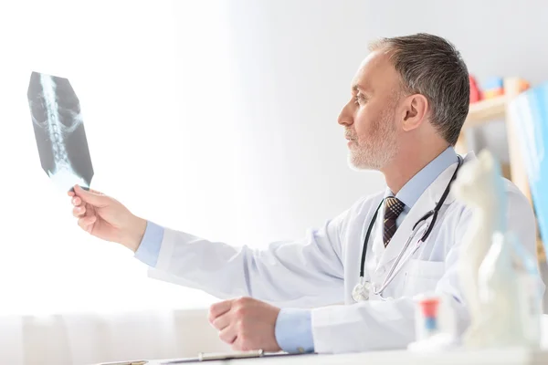 Smiling pediatrician sitting at table — Stock Photo, Image