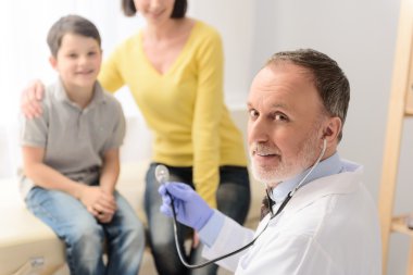 Pediatrician doctor examining child clipart