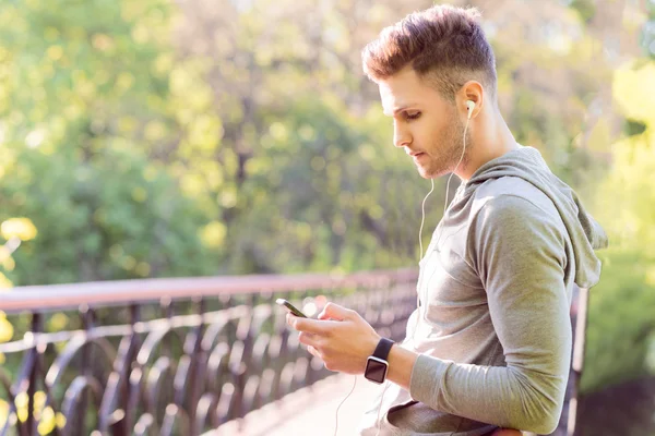 Corredor masculino pensativo usando tecnología moderna —  Fotos de Stock