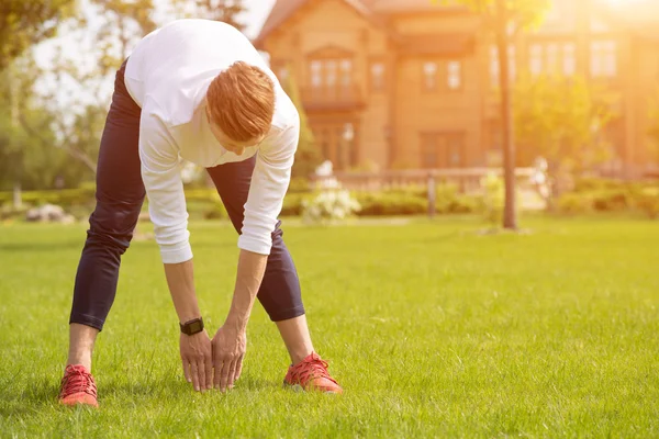 Fit sportowca robić ćwiczenia na trawie — Zdjęcie stockowe